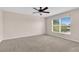 Large bedroom with carpeted floor, ceiling fan, and ample natural light from the window at 16053 Wilkinson Dr, Clermont, FL 34714