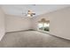 Spacious bedroom with neutral carpet, ceiling fan, and a window at 16053 Wilkinson Dr, Clermont, FL 34714