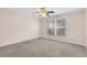 Bedroom with neutral carpet, ceiling fan, and a large window at 16053 Wilkinson Dr, Clermont, FL 34714