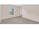 Bright empty room with neutral paint, carpeting, and a large window at 16053 Wilkinson Dr, Clermont, FL 34714