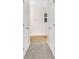 Hallway with tan carpet leads to a light-filled room with light wood flooring and window at 16053 Wilkinson Dr, Clermont, FL 34714