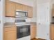 Bright kitchen with white subway tile backsplash, stainless-steel microwave, and electric stove at 16053 Wilkinson Dr, Clermont, FL 34714