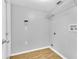 Laundry room with overhead shelving, washer/dryer hookups, and wood-look flooring at 16053 Wilkinson Dr, Clermont, FL 34714