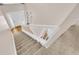 Bright entryway with a white door and wood floors visible from the top of the carpeted staircase at 16053 Wilkinson Dr, Clermont, FL 34714