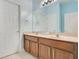 Bathroom with double sink vanity, wood cabinets, large mirror, and neutral colored countertop at 1636 Hanks Ave, Orlando, FL 32814