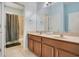 Bathroom featuring a double sink vanity with wood cabinets, a large mirror, and a shower-tub combo at 1636 Hanks Ave, Orlando, FL 32814