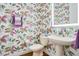 Charming powder room featuring vibrant floral wallpaper and a pedestal sink at 1636 Hanks Ave, Orlando, FL 32814
