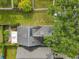 Aerial view of the house featuring a dark roof, solar panel, skylight, well-maintained lawn, and adjacent green spaces at 1751 Chatham Cir, Apopka, FL 32703