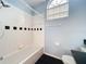 Bathroom features combination tub/shower, light blue walls and black tile floors at 1751 Chatham Cir, Apopka, FL 32703