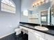 Bathroom features a large mirror, a vanity with black countertop and a window for natural light at 1751 Chatham Cir, Apopka, FL 32703
