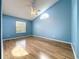 Spacious bedroom features wood-look floors, vaulted ceiling, ceiling fan and half-moon window for natural light at 1751 Chatham Cir, Apopka, FL 32703