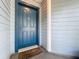 Stylish blue front door of a home with a 'Welcome' mat, set against light-blue siding at 1751 Chatham Cir, Apopka, FL 32703