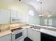 Modern kitchen features white appliances, breakfast bar, and a pass-through to the adjacent dining/living area at 1751 Chatham Cir, Apopka, FL 32703
