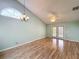 Spacious living room features vaulted ceilings, wood floors, ceiling fan, and large french doors to the backyard at 1751 Chatham Cir, Apopka, FL 32703