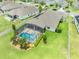 Aerial view of a screened-in pool in a well-maintained backyard, complete with tropical landscaping at 1789 Chatsworth Cir, St Cloud, FL 34771