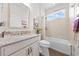 Bright bathroom features granite countertops, decorative mirror, and bathtub with tiled surround at 1789 Chatsworth Cir, St Cloud, FL 34771