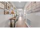 Hallway view with light wood floors and decorated walls with an assortment of photos and artwork at 1789 Chatsworth Cir, St Cloud, FL 34771