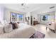 Bright main bedroom featuring three windows, a ceiling fan, and an adjacent sitting area for relaxed comfort at 1789 Chatsworth Cir, St Cloud, FL 34771