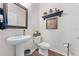 Elegant powder room with pedestal sink, decorative accents, and tiled flooring at 1789 Chatsworth Cir, St Cloud, FL 34771