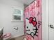 bathroom featuring a Hello Kitty themed shower curtain, toilet seat, and bathmat at 18826 Reynolds Pkwy, Orlando, FL 32833