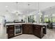 Open kitchen featuring dark wood cabinetry, granite countertops, and a built-in wine refrigerator at 18826 Reynolds Pkwy, Orlando, FL 32833