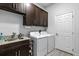 Laundry room with sink, granite countertops, and dark cabinets above washer and dryer at 18826 Reynolds Pkwy, Orlando, FL 32833