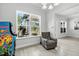 Cozy sitting area with an armchair, large windows, and view of the outdoors next to an arcade game at 18826 Reynolds Pkwy, Orlando, FL 32833