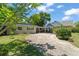 Inviting single-story home with a lovely front yard and a curved driveway leading to a carport at 1924 Summerfield Rd, Winter Park, FL 32792