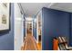 Long hallway painted blue with hardwood flooring and doors along the sides at 1924 Summerfield Rd, Winter Park, FL 32792