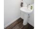 This bathroom features a stylish white pedestal sink with updated fixtures and gray wood-look flooring at 193 E Warren Ave, Longwood, FL 32750
