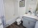 Well-lit bathroom featuring a shower-tub combo, grey vanity, white tile and wood-look floors at 193 E Warren Ave, Longwood, FL 32750
