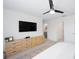 A stylish bedroom with a ceiling fan, large dresser, and neutral color palette offers plenty of space at 193 E Warren Ave, Longwood, FL 32750