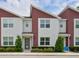 Inviting exterior of townhome featuring red accents, manicured landscaping, and large windows at 193 E Warren Ave, Longwood, FL 32750