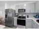 Modern kitchen featuring stainless steel appliances, gray cabinets, and quartz countertops at 193 E Warren Ave, Longwood, FL 32750