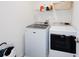 Bright laundry area features a new washer and dryer and storage shelving for supplies at 193 E Warren Ave, Longwood, FL 32750