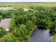 Aerial view of property bordering the canal with treed surroundings, and an arrow indicating the specific home location at 1941 Sunset Palm Dr, Apopka, FL 32712