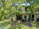 Charming townhome featuring a cozy patio, lush greenery, and shaded by mature trees at 1941 Sunset Palm Dr, Apopka, FL 32712