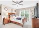 Cozy bedroom with a wooden bed frame, a nightstand, and a window with a view of the trees at 1941 Sunset Palm Dr, Apopka, FL 32712