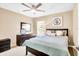 Bedroom features neutral colors, comfortable bedding, and a dark wooden dresser with mounted television at 1941 Sunset Palm Dr, Apopka, FL 32712