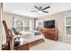 Bright bedroom features a ceiling fan, a large window, and a wooden dresser with a flat screen tv at 1941 Sunset Palm Dr, Apopka, FL 32712