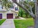 Inviting townhome with well-maintained landscaping, a single-car garage and mature trees at 1941 Sunset Palm Dr, Apopka, FL 32712