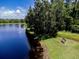 Overhead view of a pond with a small boat pulled onshore near a green bench, surrounded by trees at 1941 Sunset Palm Dr, Apopka, FL 32712