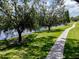 Picturesque view of a waterside walking path lined with mature trees, providing shade and scenic views at 1941 Sunset Palm Dr, Apopka, FL 32712