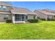 Well-kept backyard showcasing a screened porch and established hedges for added privacy at 2092 Switch Grass Cir, Ocoee, FL 34761