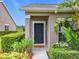 Close up shot of a front door framed by shrubs with green mulch on a sunny day at 2092 Switch Grass Cir, Ocoee, FL 34761