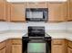 This kitchen features wood cabinets, laminate countertops and black appliances at 2092 Switch Grass Cir, Ocoee, FL 34761