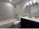 Bathroom with shower/tub combo, round mirror, updated vanity and fixtures at 212 Dorothy St, Auburndale, FL 33823