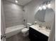 Bathroom featuring tiled shower-tub combo, and black vanity at 212 Dorothy St, Auburndale, FL 33823