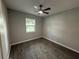Bedroom featuring neutral paint, wood-look tile floors, a window, and a ceiling fan at 212 Dorothy St, Auburndale, FL 33823