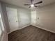 Bedroom showcasing neutral paint, wood-look tile floors, multiple doors and a ceiling fan at 212 Dorothy St, Auburndale, FL 33823